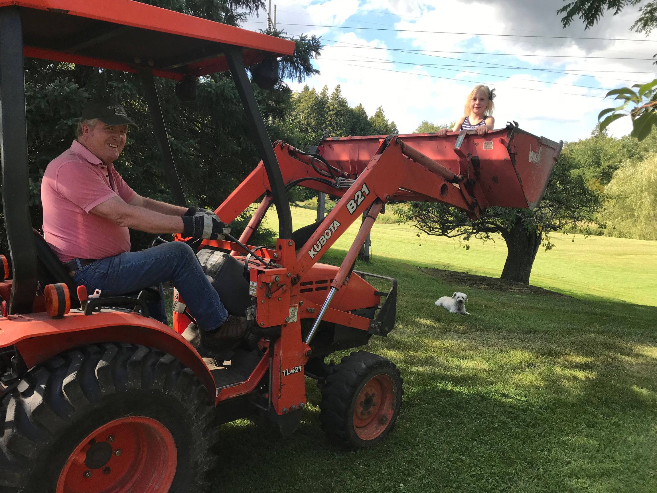 Photo of Heather with her dad on his tractor